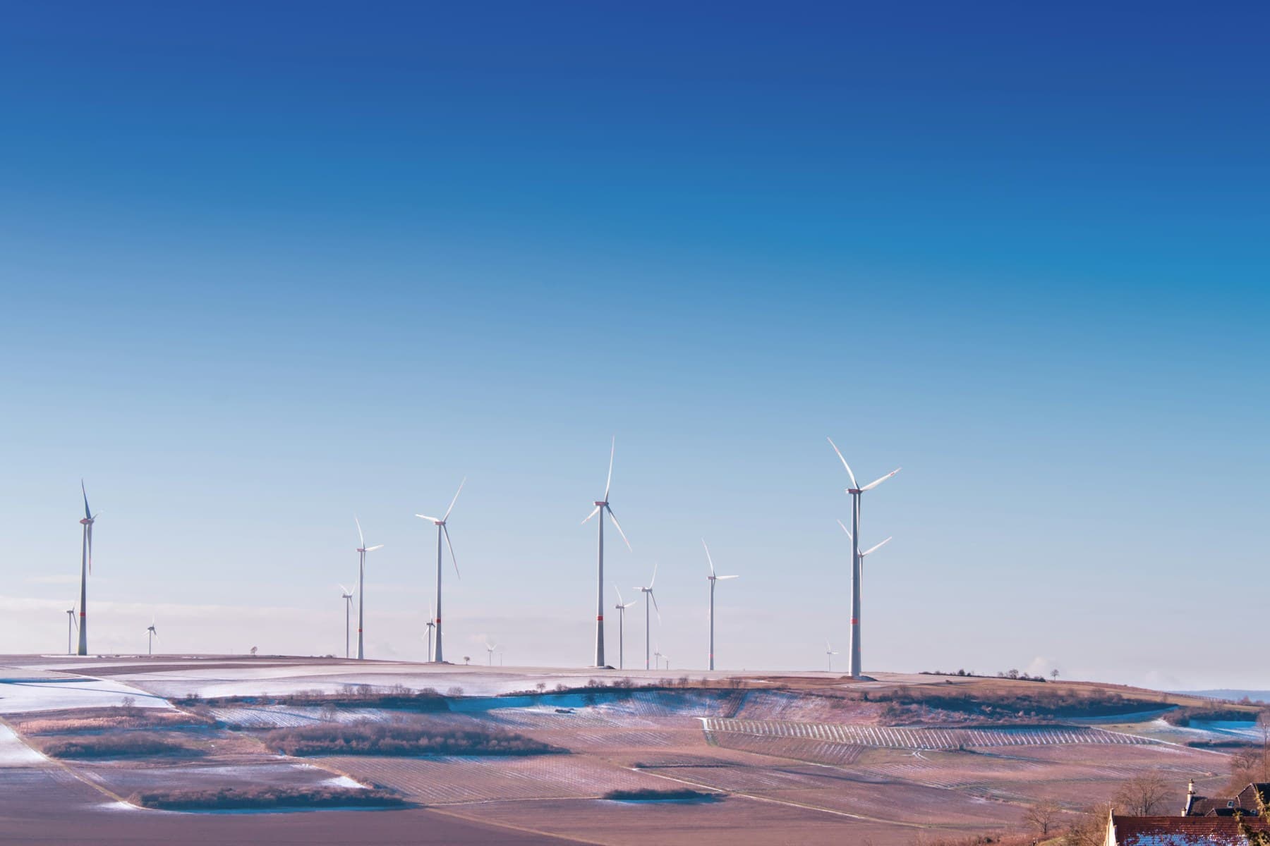 Wind turbines generating renewable electricity across open farmland